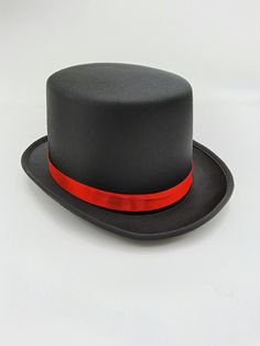 Nicky Bigs Novelties™ Black Soft Satin Top Hat With Red Band This Black Top hat is a great economically priced and economy quality item. This hat has many uses and will fit adults and some children.The interior has a measurement of approximately 22" in circumference. The inside measures approximately 6-1/2 inches from side to side and 7 7/8 inches from front to back. The total height of this hat is approximately 5 inches tall. The rest of the exterior is approximately 11.5 inches long and 9 inches wide. The brim will extend approximately 2 inches off the front and back of the hat, and 1-3/8 inches off the sides. The hat band measures approximately .75" inches tall.  Head Size: Up To 57 cm Or 7 1/8 Designed for ages 14 and up. Keep Away from Fire. Handmade, assembled, and crafted by hand wi Top Hat With Red Ribbon, Snowman Top Hat, Sewing Equipment, Black Top Hat, Red Band, Costume Hats, Satin Top, Hat Band, Mad Hatter