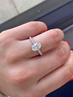 a woman's hand with a diamond ring on top of her finger and an engagement band