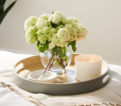 a tray with flowers and a candle on it