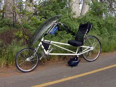 a bike with a tent attached to the back is parked on the side of the road