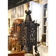 an ornate metal lantern hanging from a chain in a room filled with furniture and decor