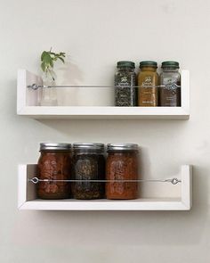 two white shelves with jars and spices on them, one is filled with dried herbs