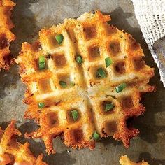 two waffles with green peppers on them sitting on top of a table next to a napkin