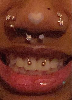 a close up of a person's teeth with piercings