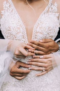 the bride and groom are holding each other's hands with wedding rings on their fingers