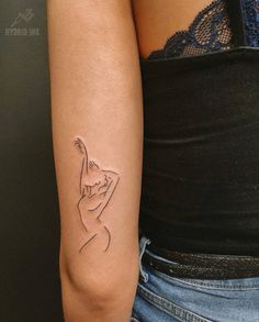 a woman's arm with a small tattoo on the left side of her arm