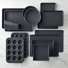 an assortment of black baking pans and muffin trays