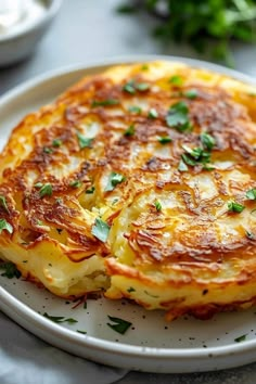 a white plate topped with two cheesy cakes on top of a table next to other dishes