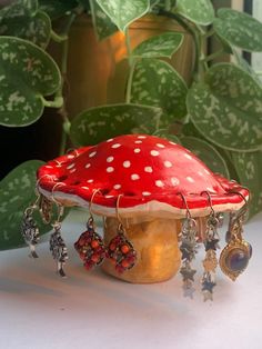 a red mushroom sitting on top of a table next to a potted plant