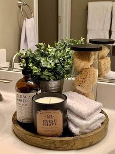 a tray with candles, soaps and towels on it in front of a mirror