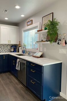 a kitchen with blue cabinets and white counter tops