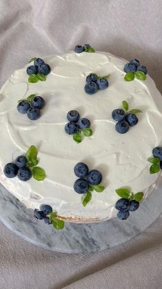 a cake with white frosting and blueberries on it