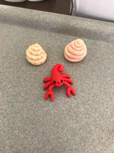 there are two cupcakes with icing on them and one has a red crab