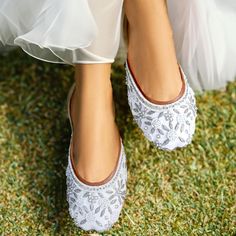 the bride's shoes are white and decorated with floral designs on them, while her dress is sheer