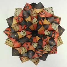 a circular arrangement of orange and black paper flowers