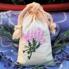 a bag filled with purple flowers sitting on top of a blue cloth covered tablecloth