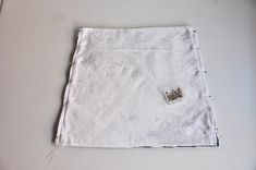 a piece of white cloth with a small patch on the edge and some thread in it