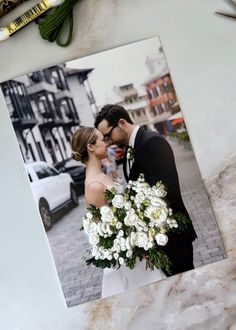 a couple kissing in front of a photo with flowers and crayons on the table