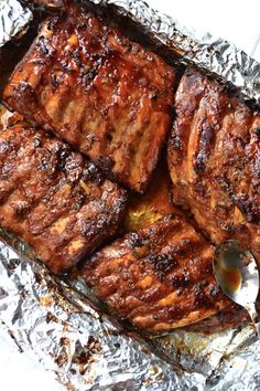 grilled steaks on tin foil with a spoon in the middle, ready to be eaten