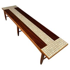 a wooden bench with white and brown tiles on it's back end, sitting in front of a white background