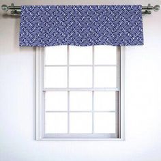 a window with a blue and white patterned valance hanging from it's side