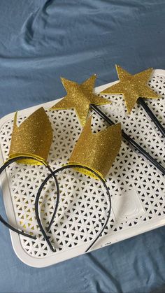 three gold glitter mouse ears on top of a white tray with black headbands