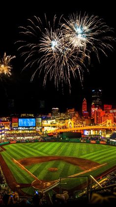 fireworks light up the night sky over a baseball field