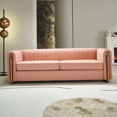 a pink couch sitting on top of a white floor next to a fire place in a living room