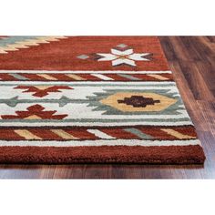 an area rug with various colors and designs on it in the middle of a wooden floor