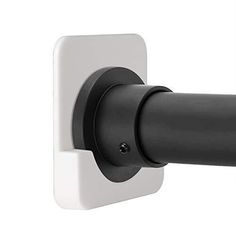 a black and white door handle on the side of a wall mounted toilet paper dispenser