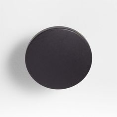 a black knob on a white wall