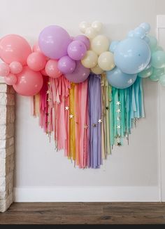 there are balloons and streamers hanging on the wall in front of a fire place