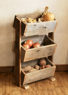 an old wooden box filled with vegetables on top of a hard wood floor next to a wall