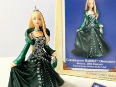 a barbie doll next to a book and an ornament on a white table