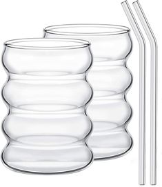 three clear glass cups with two drinking straws next to each other on a white background