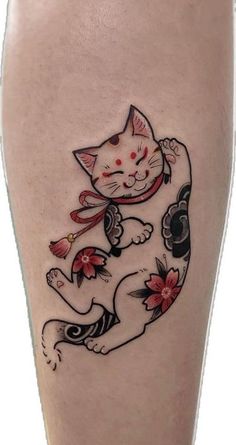 a cat tattoo on the leg of a woman's leg, with flowers around it