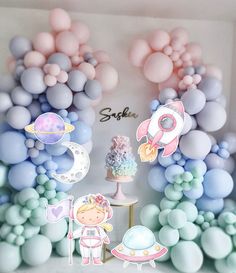 a space themed birthday party with balloons, cake and decorations in pastel blue tones