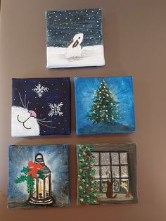 four small paintings are hanging on the wall in front of a christmas tree and window