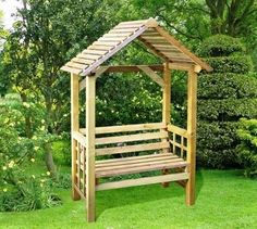 a wooden bench sitting in the middle of a lush green field