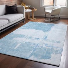 a living room filled with furniture and a large rug on top of a hard wood floor