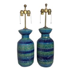 two blue and green vases sitting next to each other