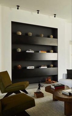 a modern living room with black shelves and white walls