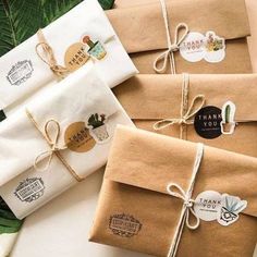 three wrapped gift bags tied with twine and some stickers attached to each package