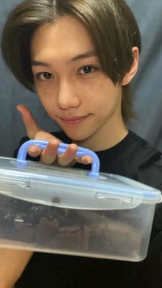 a young woman holding a plastic container with something in it