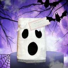 a white towel with black spots on it sitting in front of a purple sky and bats