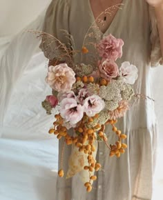 a woman holding a bouquet of flowers in her hands