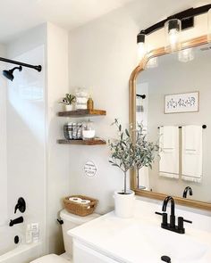 a bathroom with a toilet, sink and mirror