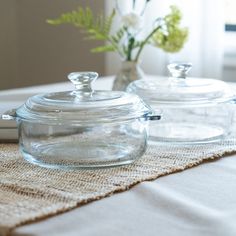 two glass jars sitting on top of a table