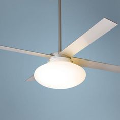 a ceiling fan with a white light on it's side and a blue sky in the background