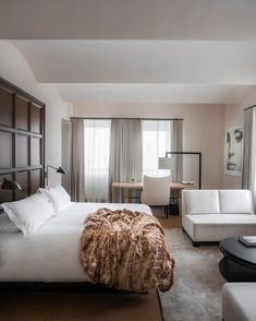 a large bed sitting in a bedroom next to a white couch